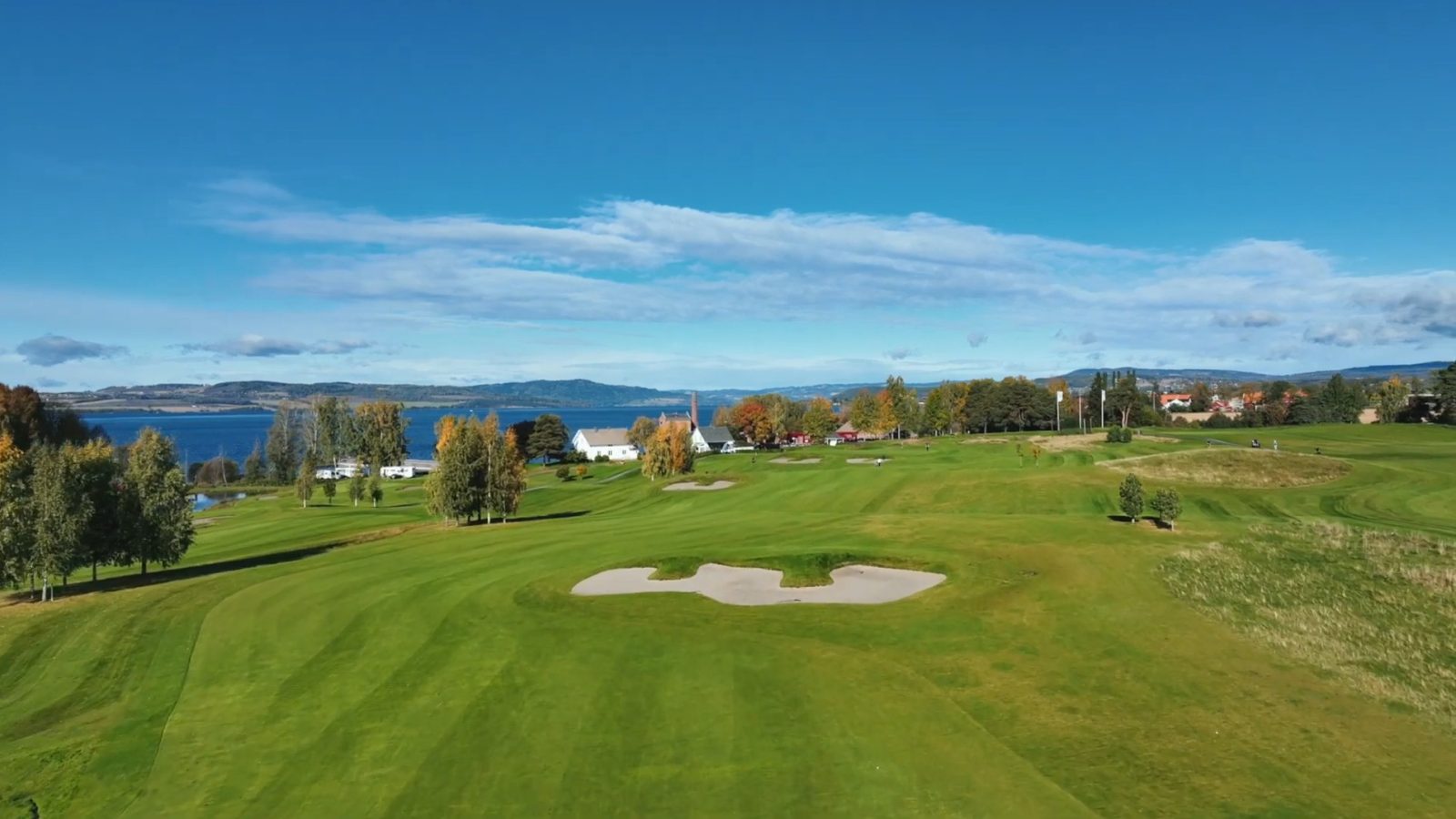 Fairway og bunkere på Atlungstad, med brenneripipa og Mjøsa i bakgrunnen