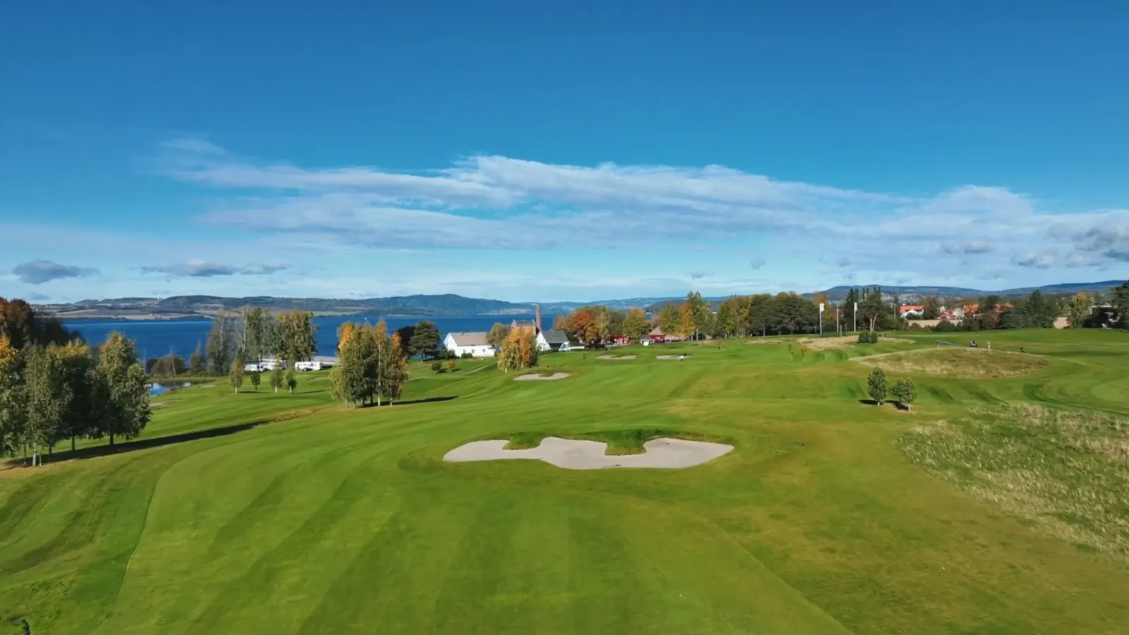 Fairway og bunkere på Atlungstad, med brenneripipa og Mjøsa i bakgrunnen